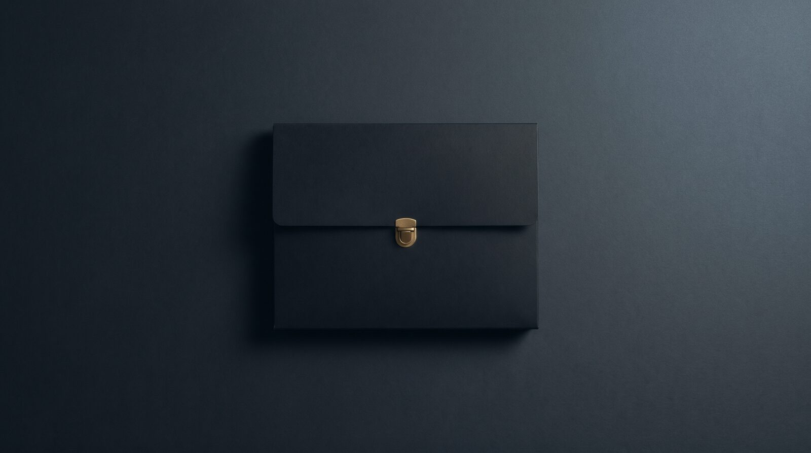 A matte black document folder, closed, with one small brass clasp